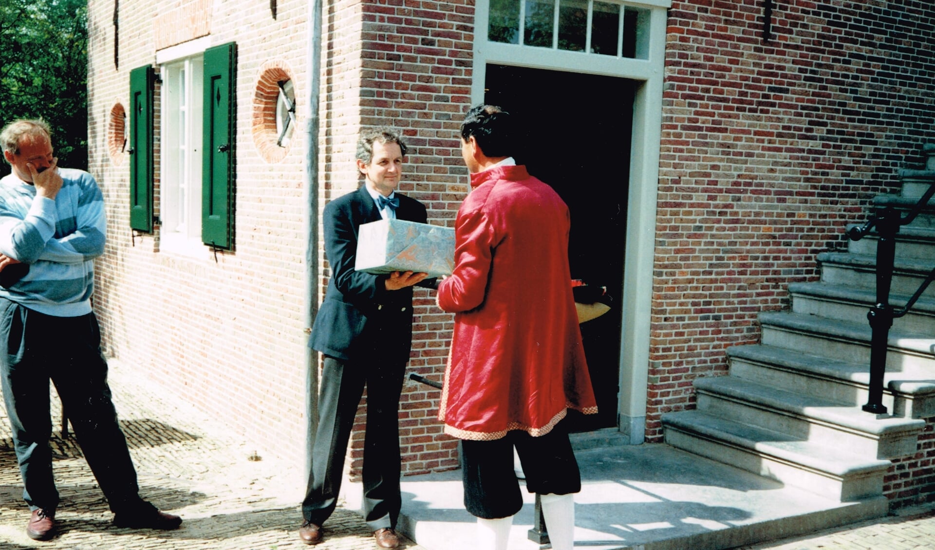 Er werd een cadeau overhandigd namens Het Bouwfonds;  wethouder Dinand de Ridder bekijkt het tafereel. 