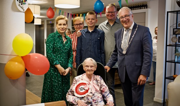 Mevrouw Wieczorek omringt door haar familie en burgemeester Hans Romeyn.