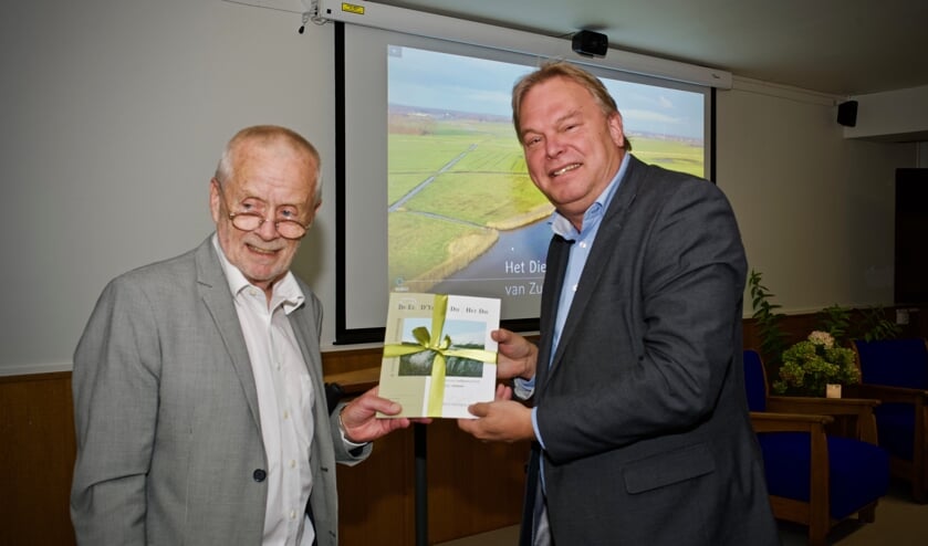 Wethouder Rob Opdam neemt het boek over Het Die in ontvangst.