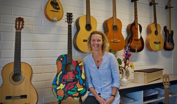 Susan Groot met haar kleurengitaar welke zij ooit op een veiling bij de St. Radboud gekocht heeft.