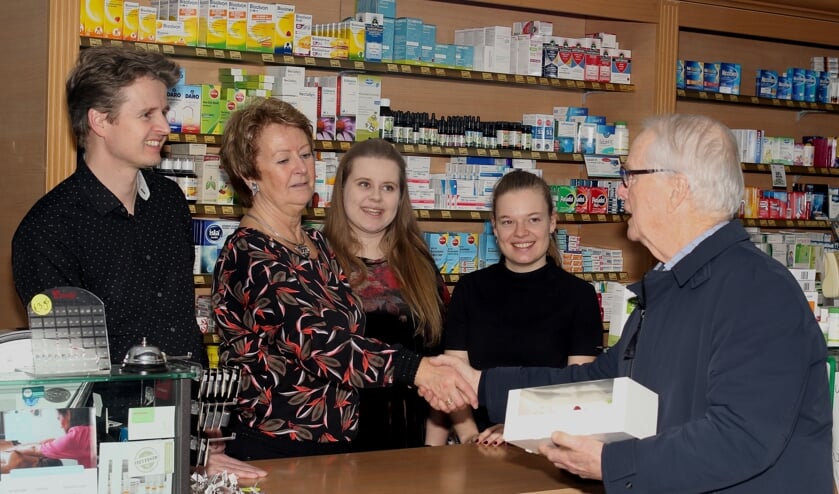Een bestuurslid van de Lionsclub Alkmaar Phoenix brengt een taart bij Drogisterij Aker in Limmen, als dank voor hun resultaat.