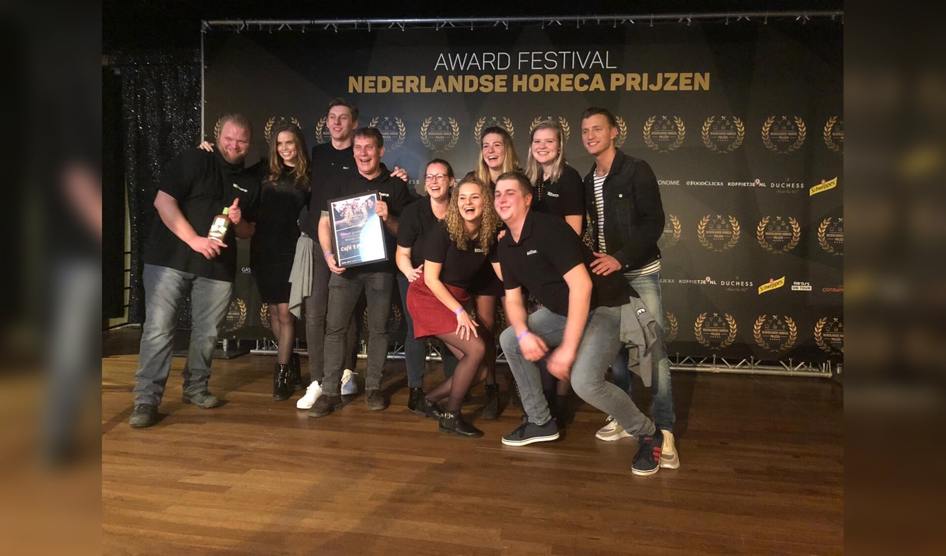 Het team van café 't Portiertje ontvangt de award van Jan Versteegh.