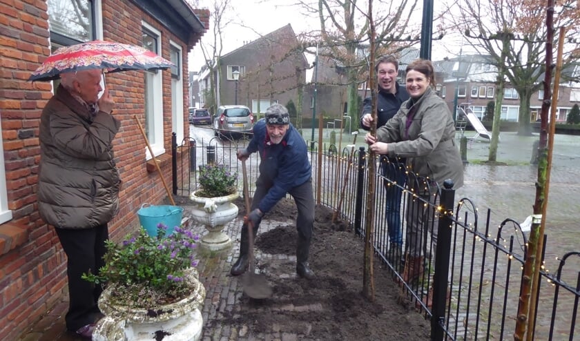 Nico Brantjes plant boompjes in de voortuin onder toeziend oog van Ilona en haar man Rob van Thuisbij.