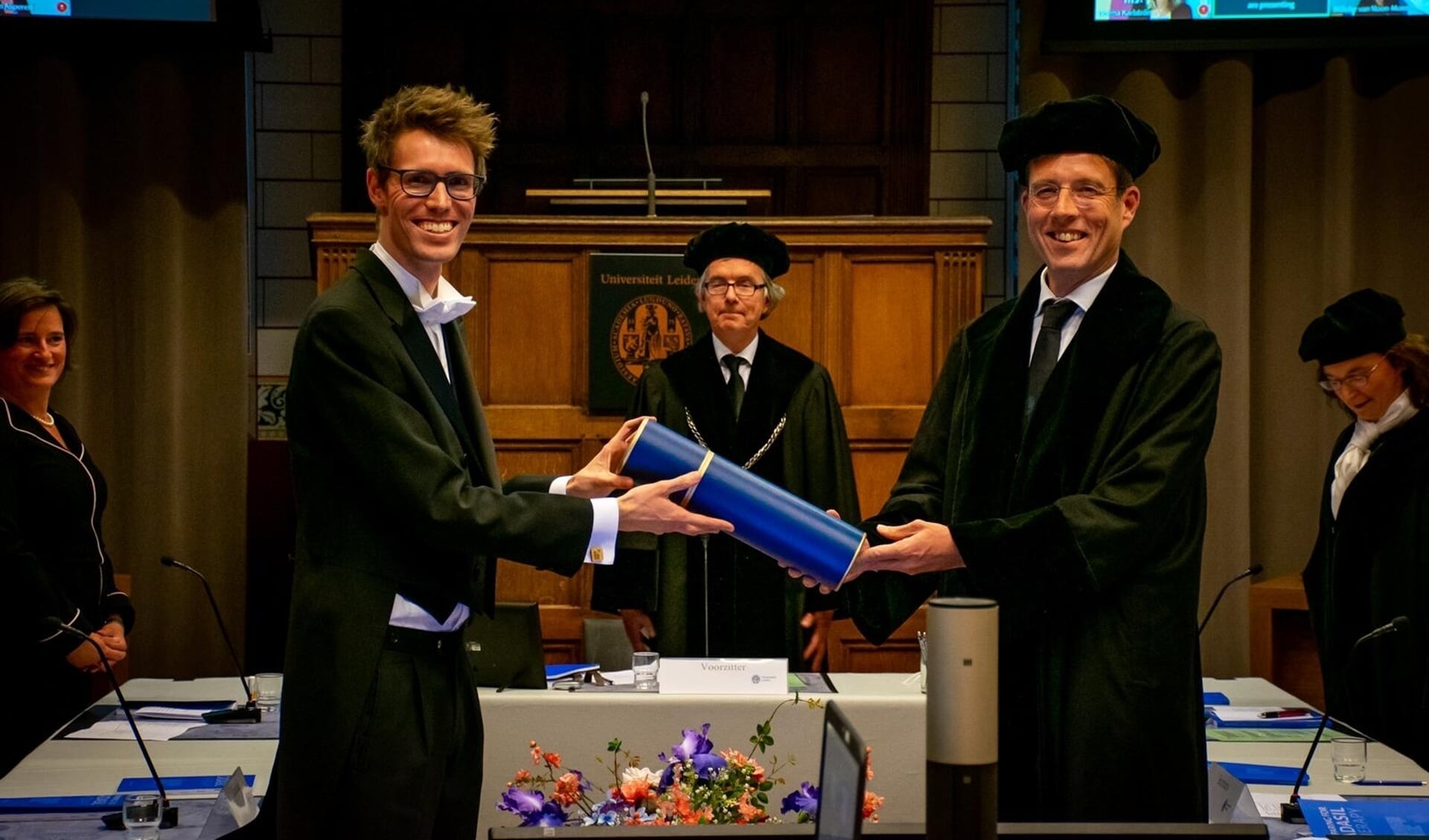 Gido Gravesteijn (links) ontvangt de bul uit handen van professor Onno Meijer.