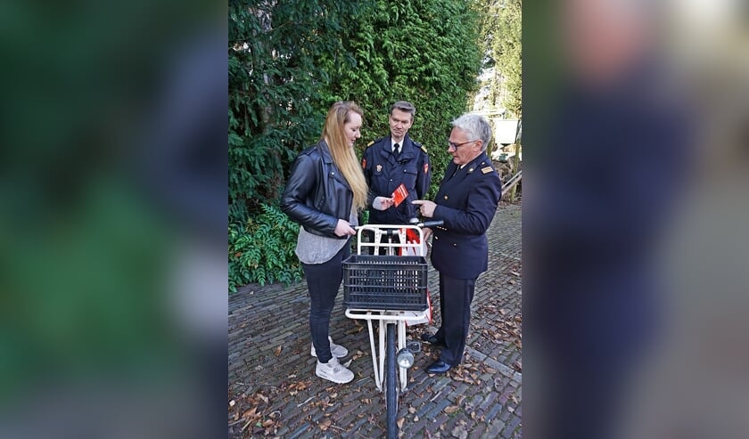 Martin Rensen (L) en Peter Weerd (R) overhandigen een cliënt van de voedselbank een fiets.
