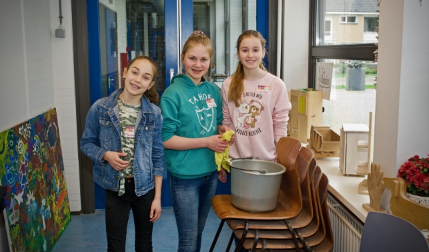 Femke, Jolien en Dirkje maken met een sopje de vensterbanken schoon.