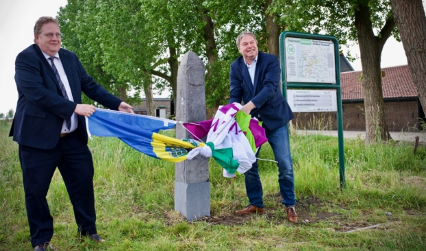 De onthulling van de grenspaal. Op de foto wethouders Paul Slettenhaar en Rob Opdam.