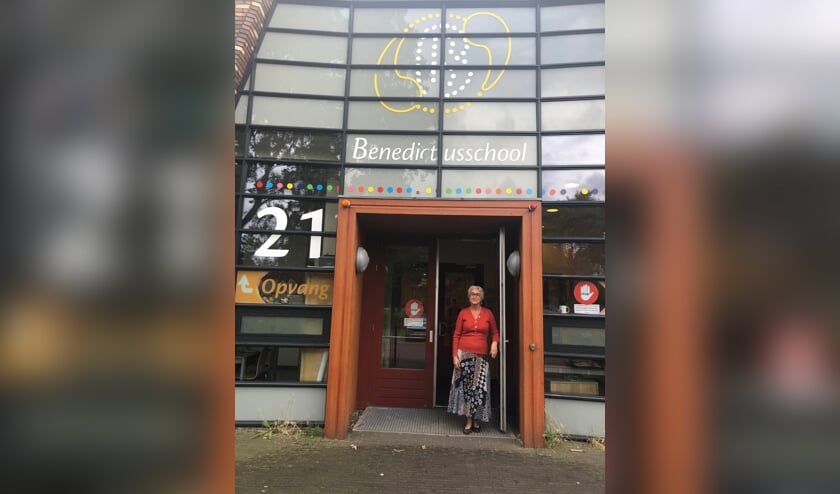 Juf Theresia zoals iedereen haar kent: in de deuropening van de Benedictusschool.