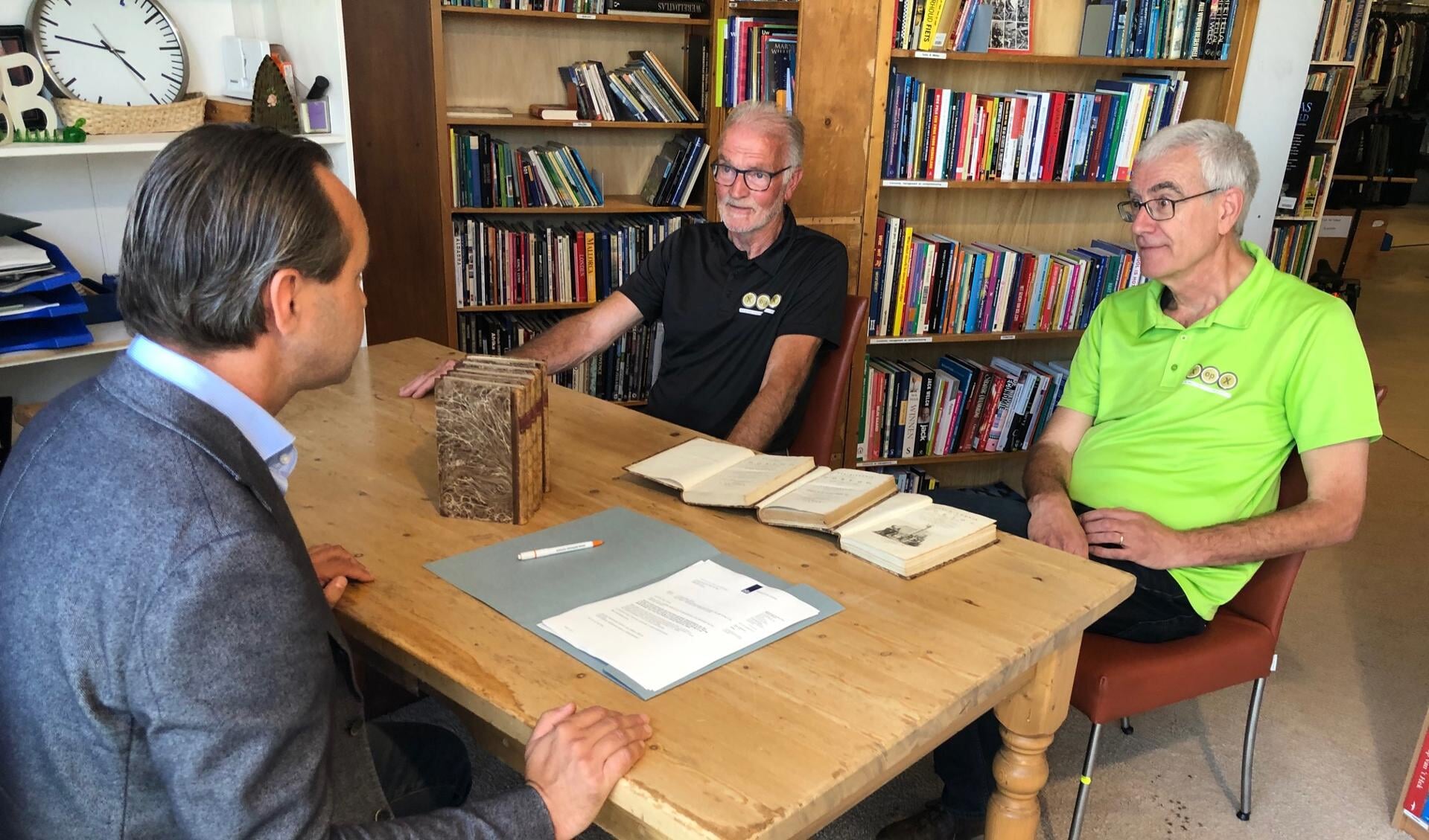 Penningmeester George Tervoort (l) en Wim Maan (r) , vrijwilliger op de boekenafdeling van XopX tekenen de akte van schenking.