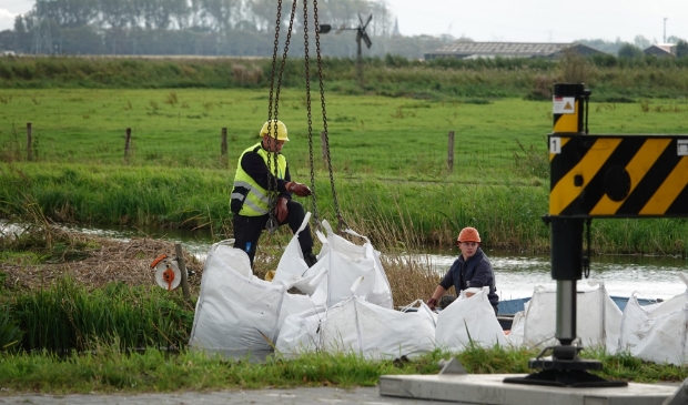 De sloot wordt afgedamd om te voorkomen dat het vervuilde water uit de sloot richting Binnenmeer of Uitgeestermeer stroomt.