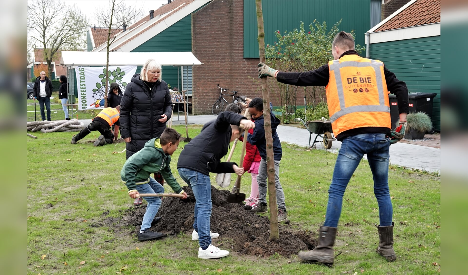 Onder aanmoediging van wethouder Cecilia van Weel planten Vrijburg-leerlingen bomen in de Plevierstraat.