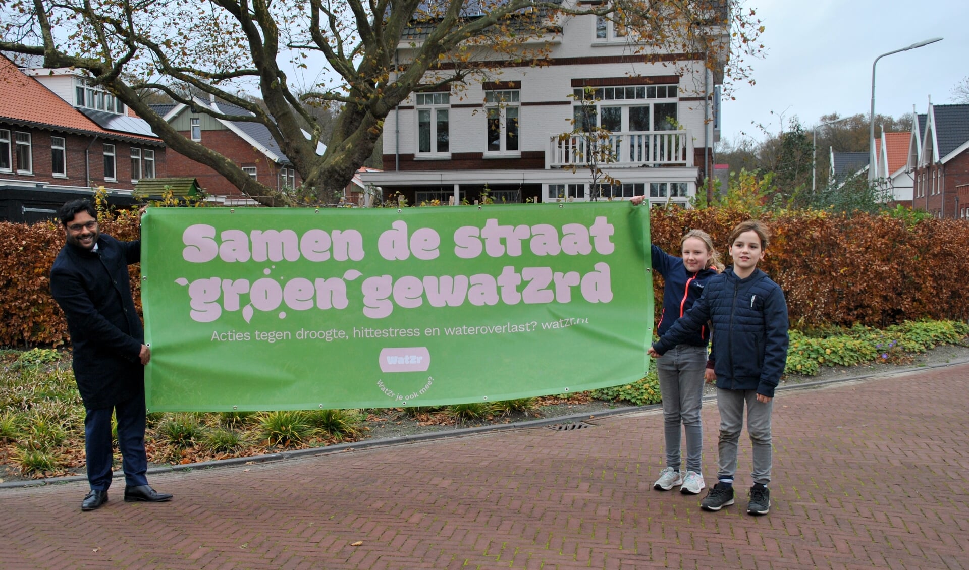 Wethouder Falgun Binnendijk overhandigde aan buurtkinderen Xavier en Mirthe een mooie banner van de WatZr-campagne