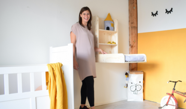 Melanie van Hagen bij een wandcommode van Babywoods.