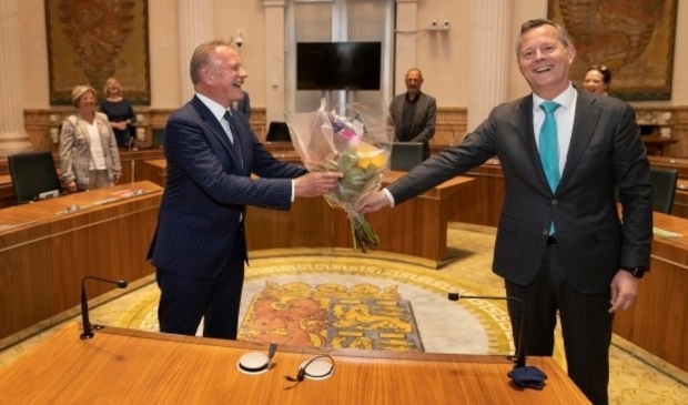 Commissaris van de Koning in Noord-Holland Arthur van Dijk overhandigt een welkomstbloemetje aan waarnemend burgemeester van Heemskerk K.S. Heldoorn (links).