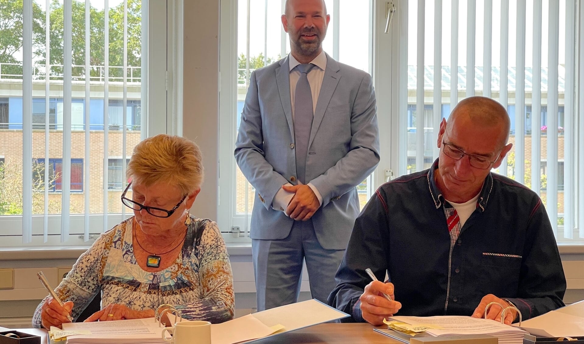 Christel en Siem Mol tekenen koopcontract in het bijzijn van burgemeester Nieuwland.
