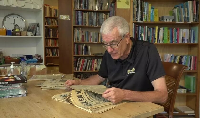 <p>Vrijwilliger Wim Maan bladert door de bijzonder vondst.</p>