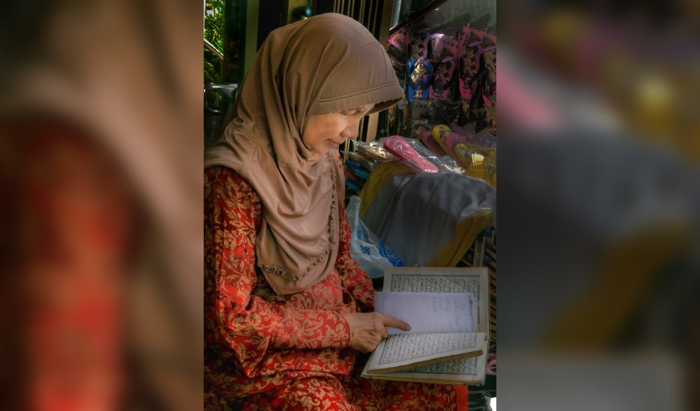 Derde prijs: Moslima leest Koran in de winkel en heeft even geen tijd voor klanten. Toegewijd en devoot. 