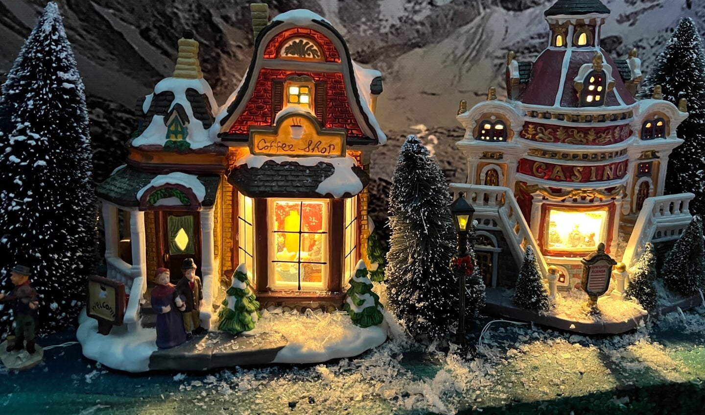 De lichtjes in de kerstdorphuisjes branden uitnodigend.
