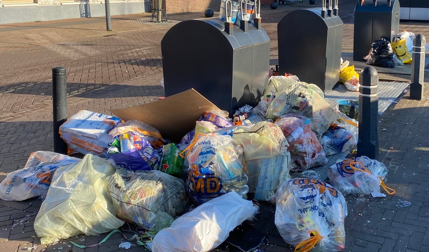 Afval naast de containers op de Bleekplaats in Schinveld, donderdagmorgen na carnaval