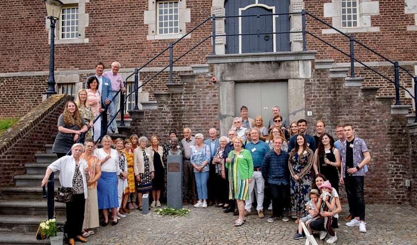 De familie Luijten poseert bij het beeld van hun voorouder Etngen Luijten, de heks van Limbricht.