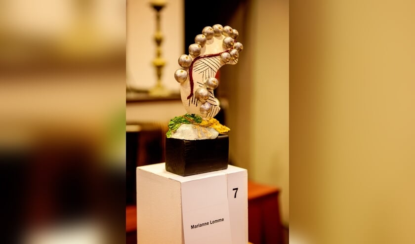 Werk van Marianne Lomme. zij voorzag de letter C van Crescendo van gouden stemmen en werkte met muziekpapier.