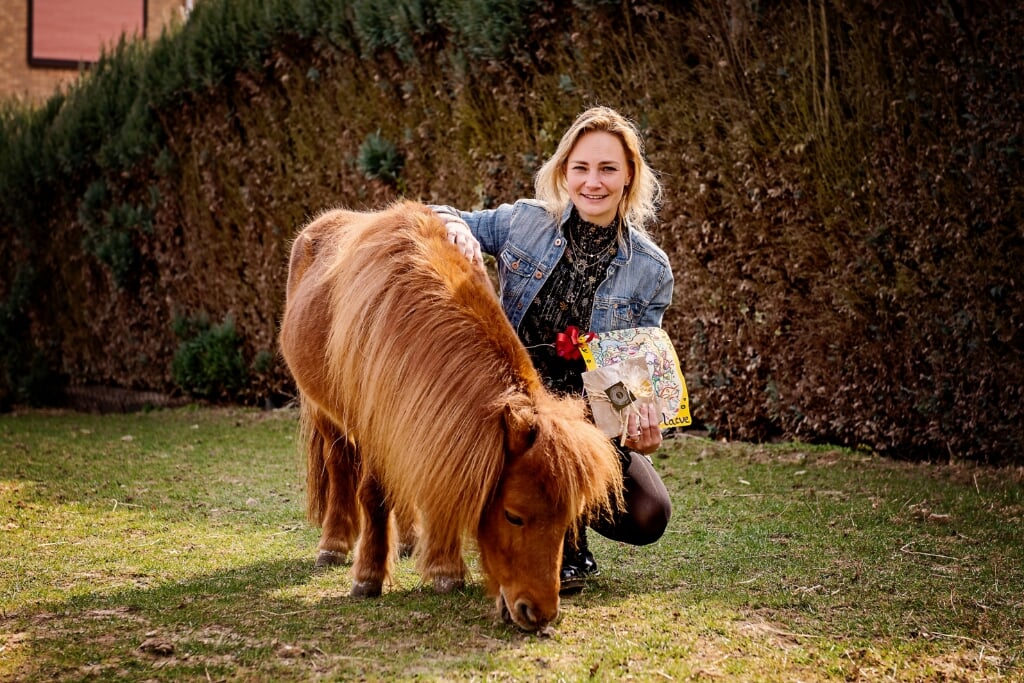 Kleurplaatwinnares Nathalie poseert met paardje Luca, de kleurplaat en de prijs in het weiland naast haar huis. | Foto: Katja Waltmans