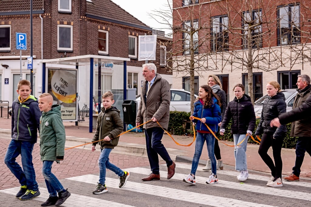 Burgemeester Eric Geurts wandelt samen met leerlingen van BS Schinveld de route van het wandelmuseum. Het oranje lint werd bij verzorgingstehuis Aan de Bleek doorgeknipt als openingshandeling.