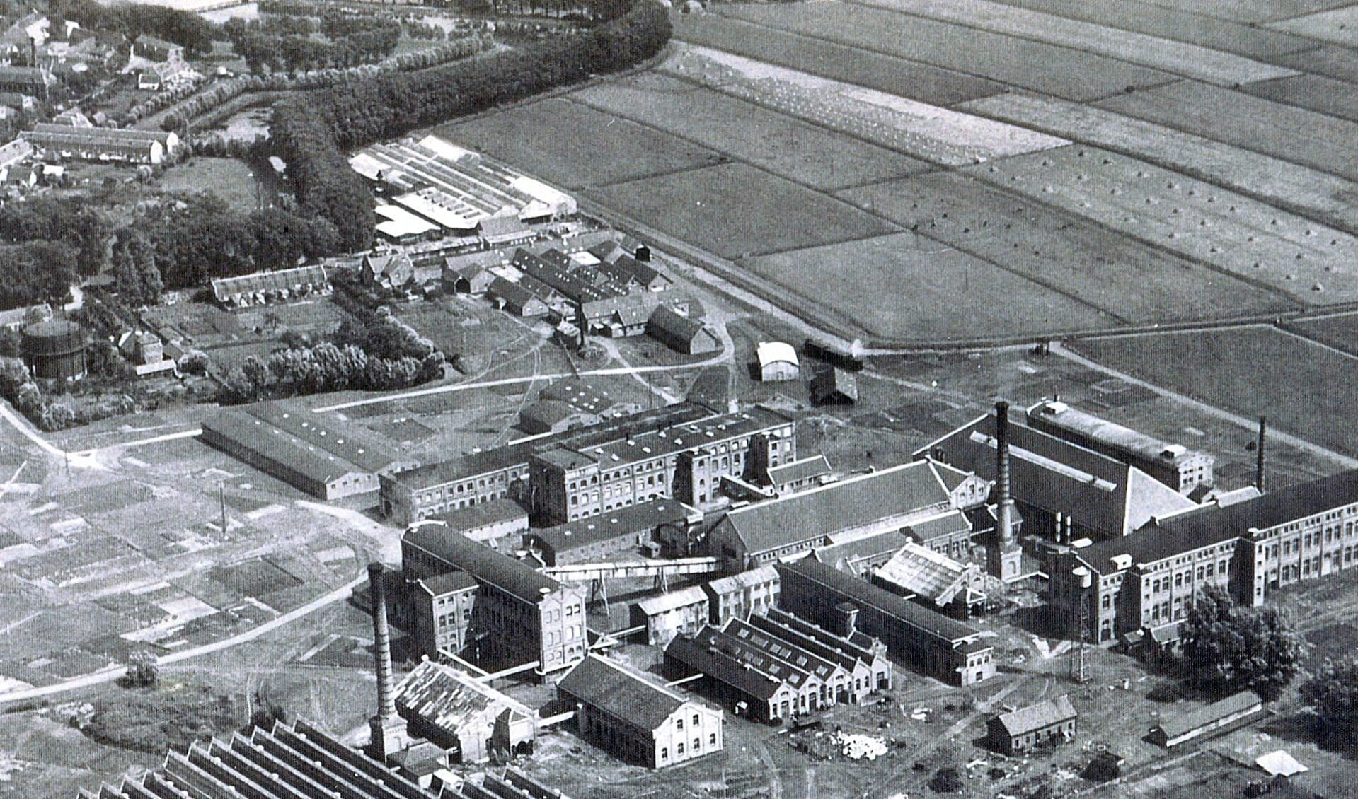 Een luchtfoto van de RAF uit maart 1945. De witte lijn bovenaan begint bij het stadhuis en bestaat uit de Breedstraat, de Groene Weg en de Van Houtenlaan. Links bovenaan de Fokkerfabriek. Rechts van de weg (helemaal bovenaan) het Van Houten-complex. Daaronder de woonhuizen aan het Singel en het barakkenkamp De Roskam.