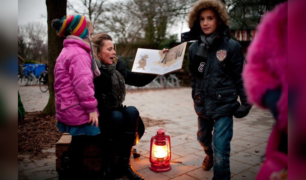 Leerlingen worden voorgelezen bij olielampen