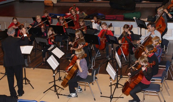 Kinderen geven een orkest op de blaasinstrumenten