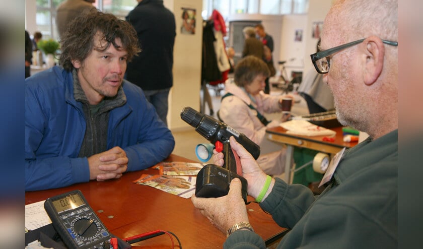 Reparateur Theo herstelt de boormachine van iemand.