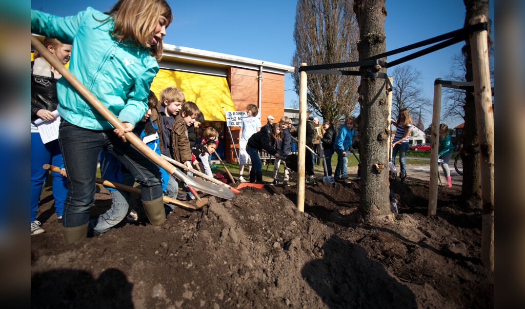 Kinderen planten bomen bij de Triangel