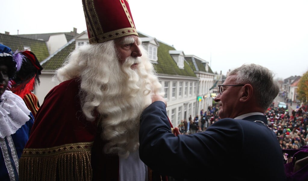 Burgemeester  speldt Sinterklaas de erespeld op