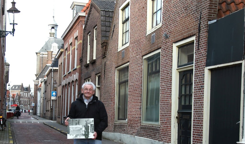 Jan Detering in 2013 bij het pand van de bakkerij in de Nieuwstraat. In zijn handen een foto van jonge Jan met de bakkersfiets