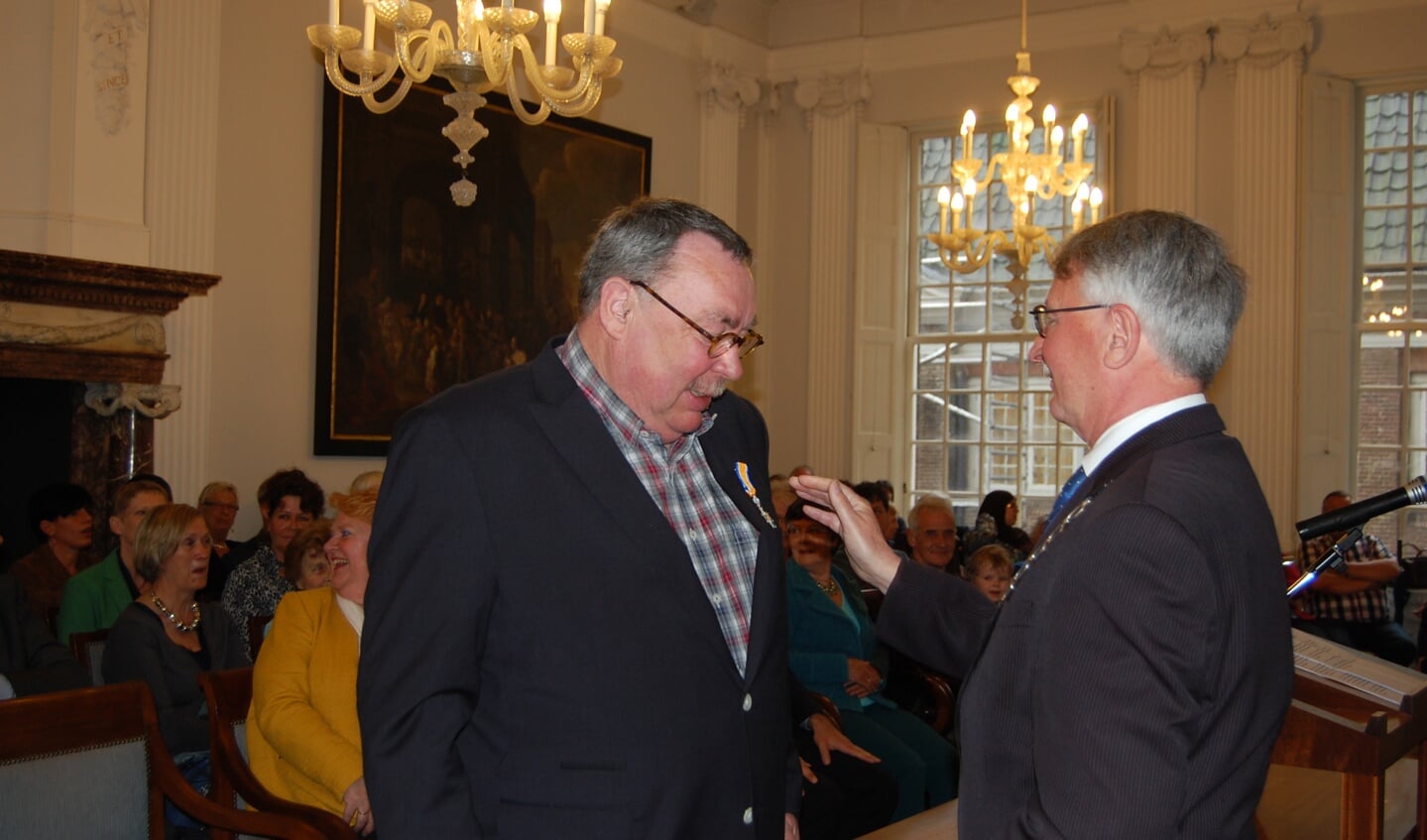 Burgemeester Horseling speldt lintje op bij Wim Gijben (links).