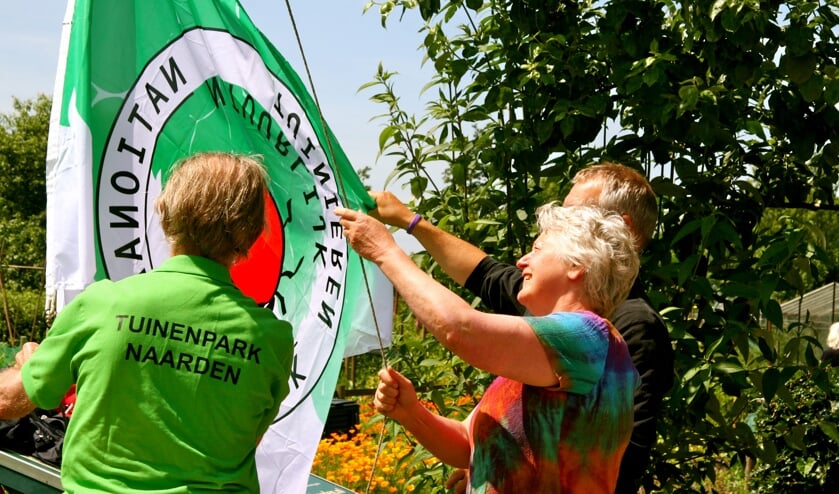 Ter ere van het keurmerk hijst wethouder De Vries de vlag.