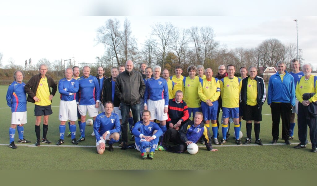 Laurens Brouwer staat te midden van de spelers van FC Weesp (in blauw shirt) en SC Muiderberg.