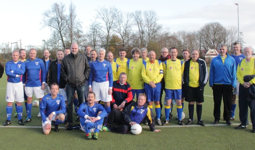Laurens Brouwer staat te midden van de spelers van FC Weesp (in blauw shirt) en SC Muiderberg.