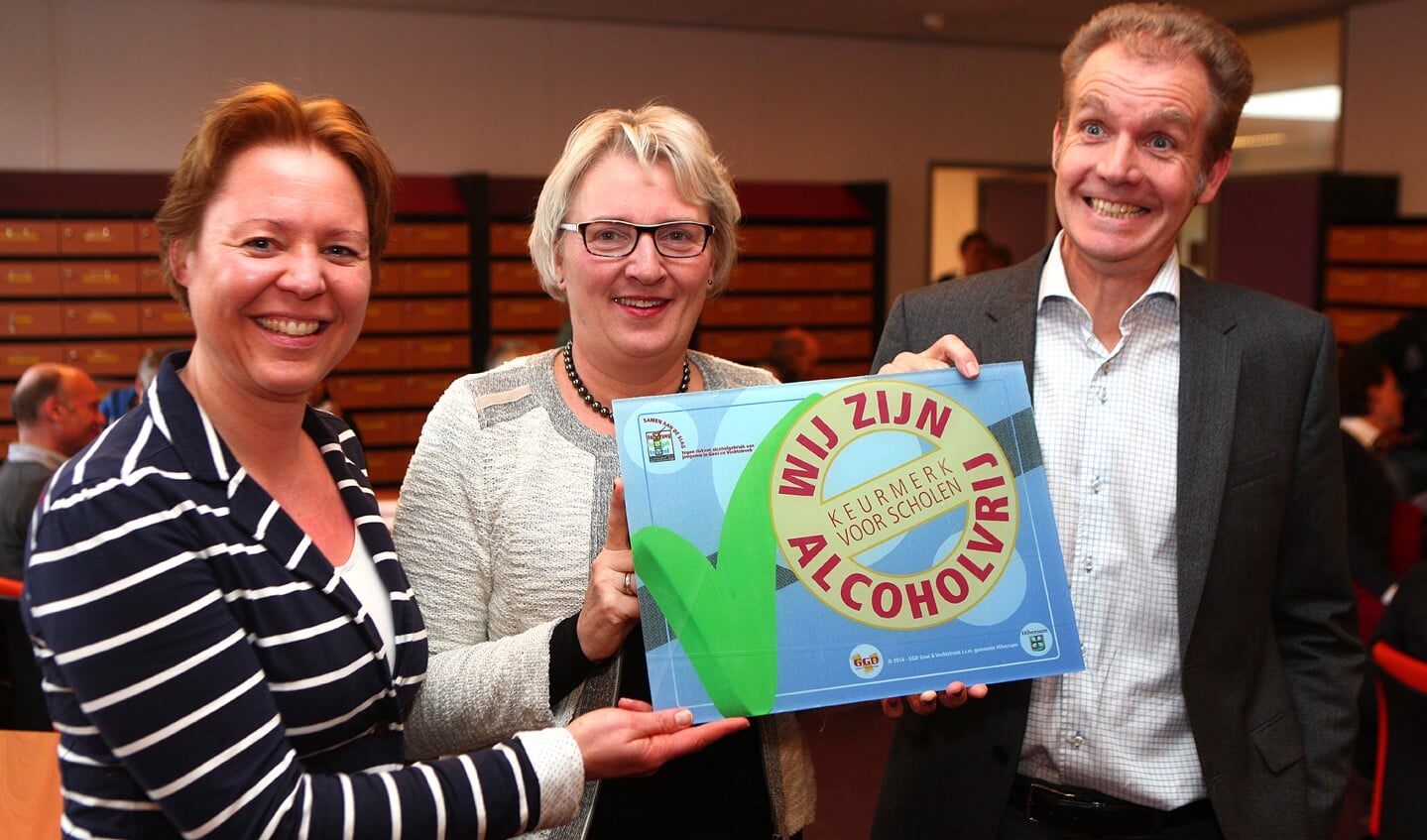 Rector Jacobi is blij met het vignet dat hij uit handen van de wethouder (midden) krijgt.