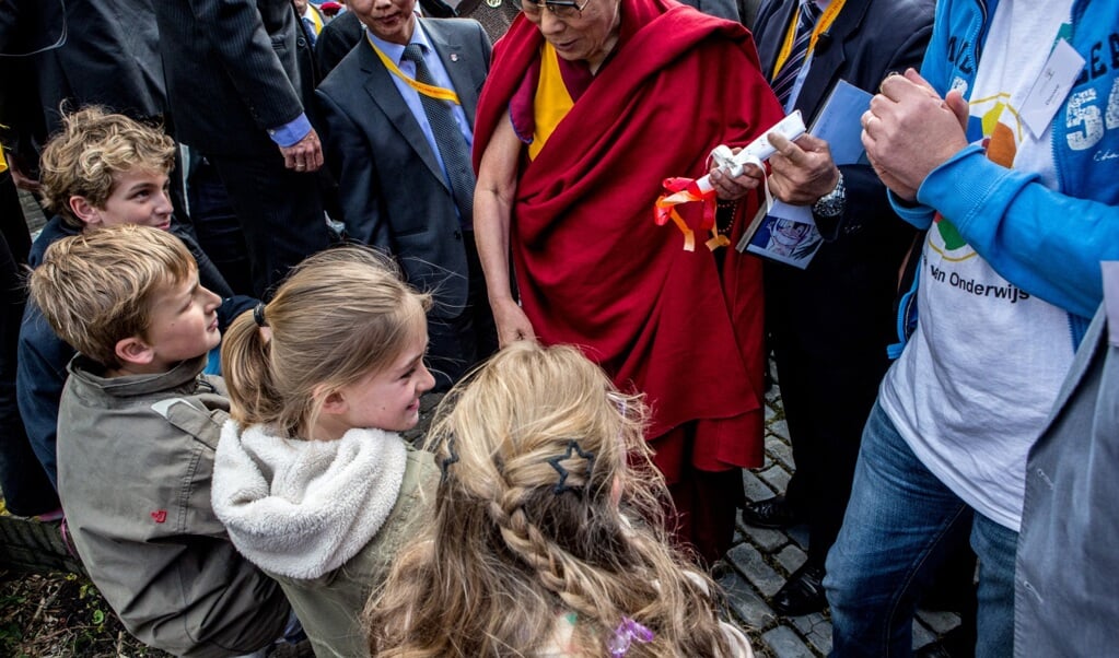 De Dalai Lama neemt de tijd voor de kinderen.