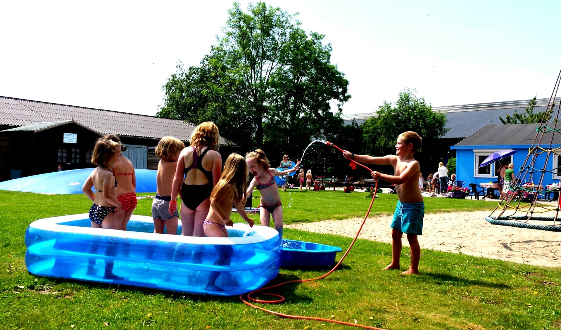 Kinderen zoeken verkoeling in speeltuin