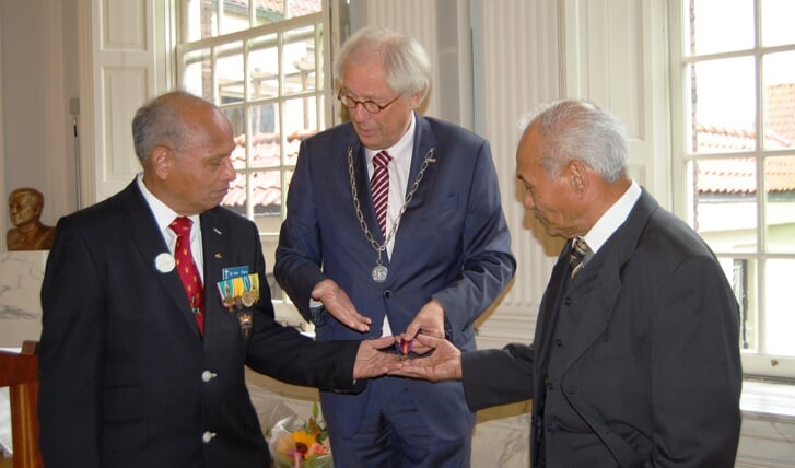 Burgemeester Van Bochove (m) overhandigt de medaille aan de broers Pierre (l) en Richard (r)