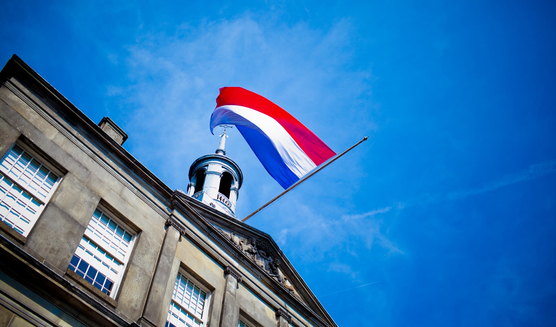 De Nederlandse vlag op het stadhuis hangt halfstok. .