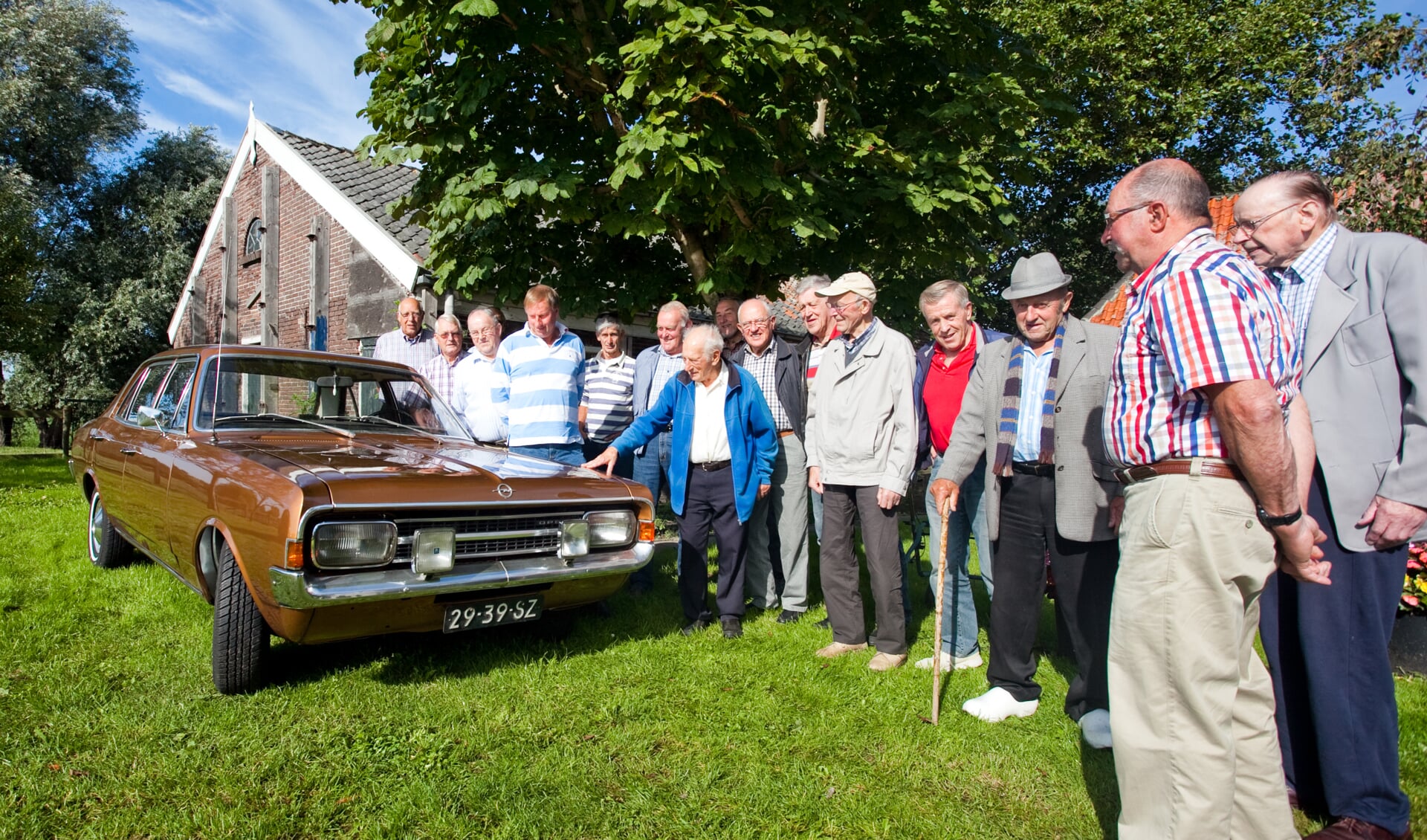 Fey (met hand op motorkap) bekijkt auto vanTerbeek (blauw-wit gestreepte shirt)