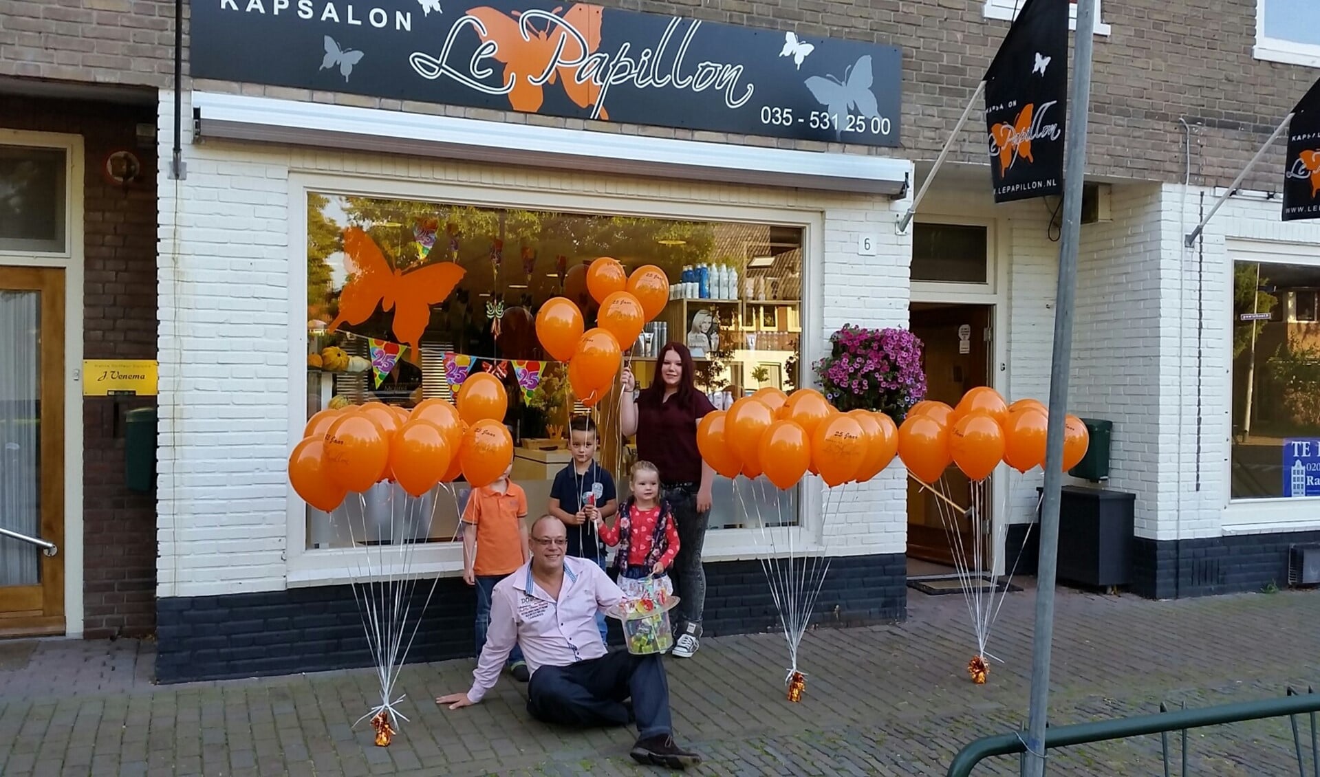 Sander voor de salon met de ballonnen die hij uitdeelt.