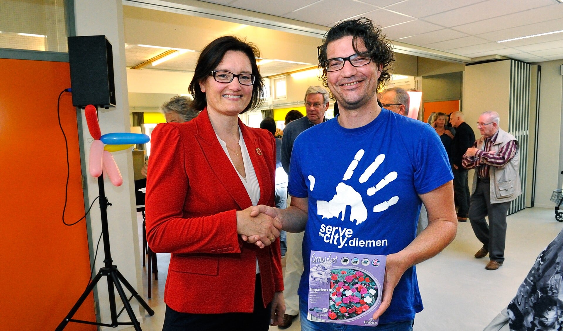 Wethouder Maïta van der Mark feliciteert Marten van den Poll, bestuurslid van StC Diemen, met de eerste prijs in de actie 'Kleine daad, groot resultaat'.