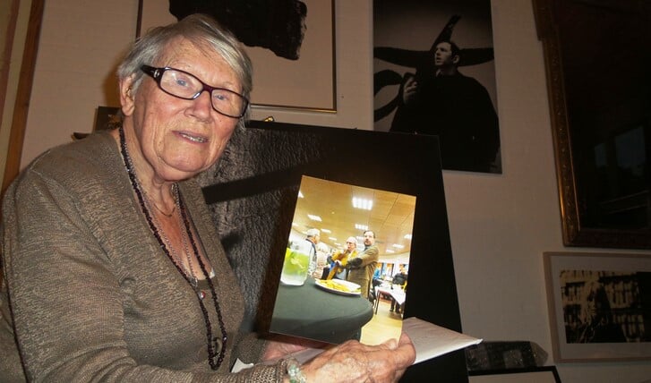 Ama Kaag toont in haar atelier in het Rosa Spier Huis een foto die ze maakte in het Brinkhuis. Op de achtergrond het portret van Anton Corbijn aan de muur.