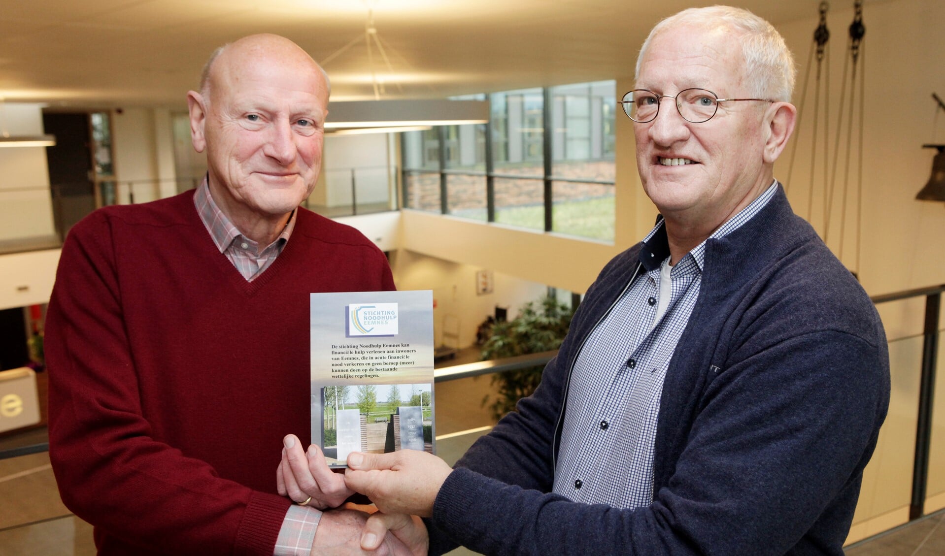 Jan Velthuis overhandigt de folder aan de wethouder. Foto: Studio Kastermans)