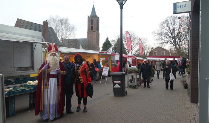 Sint en Piet poseren met marktmeester Henk van Mispelaar ter gelegenheid van de opening van de markt op het Minnehof.