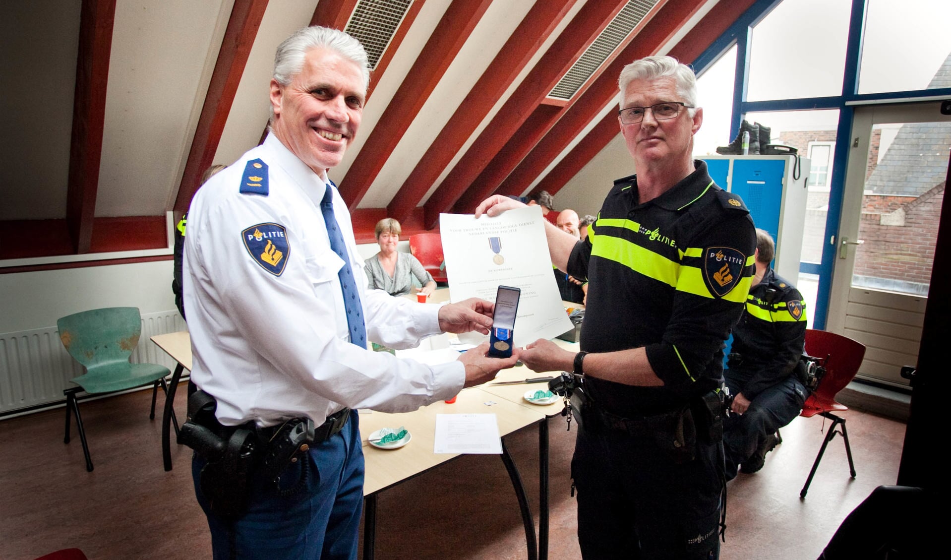 Ton Nieuwpoort (r) krijgt medaille van commandant voor jarenlang politiewerk